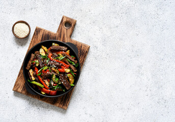 Frying pan with vegetables and beef and sesame seeds. Asian food.