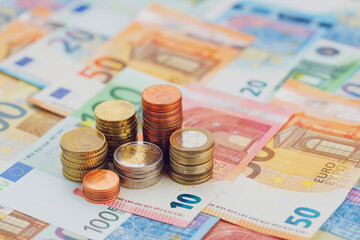 Columns of euro coins close up of euro banknotes. The concept of economics and finance. The background is blurred.