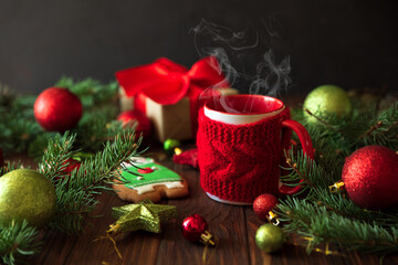 Hot Christmas tea with steam and gingerbread cookie on wooden table. New Year and Christmas celebration concept.
