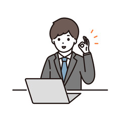 ノートパソコンの前でOKサインをするスーツ姿の若い男性