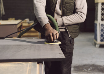 carpenter sanding a wooden board