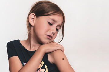 A dangerous tick crawls on the child's hand. girl is afraid of insects.