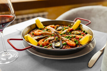 Side view on spanish seafood paella pan with mussels and shrimp
