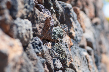 natürliche, grobe und raue Lavastein Wand in grau, schwarz, rot-braun