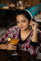 Portrait of a pretty female drinking juice while sitting in a restaurant.