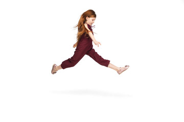 Obraz na płótnie Canvas Jumping, flying. Happy, smiley little caucasian girl isolated on white studio background with copyspace for ad. Looks happy, cheerful. Childhood, education, human emotions, facial expression concept.