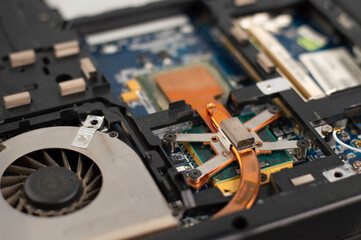 Blurred image of a fragment of a disassembled laptop. Cooler in the dust.