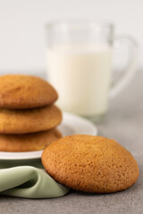In the foreground, a blurred image of cookies and a cup of milk on a light background.