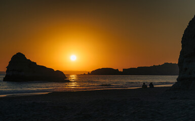 Couple Silhouette at sunset in the beach, Algarve, Portugal