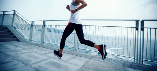 Healthy lifestyle fitness sports woman runner running on seaside trail