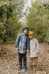 Obraz premium beautiful couple of children, boy and girl have a sincere friendship with each other and have fun and pose for a photo on a walk in the park