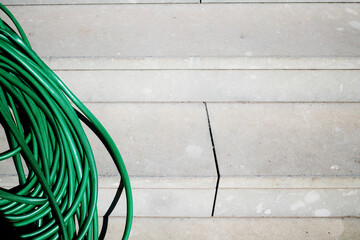 green garden hose on concrete floor