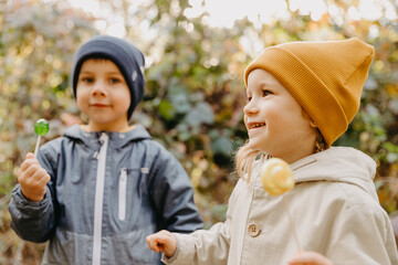 beautiful couple of children, boy and girl have a sincere friendship with each other and have fun and pose for a photo on a walk in the park