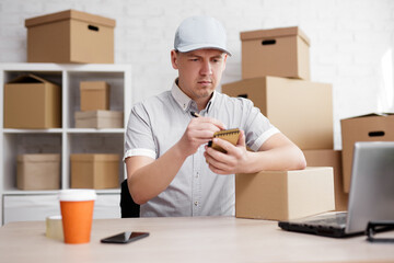 Man writing a note in a notebook at the post office