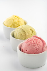 Different ice cream balls in a bowl, isolated on a white background