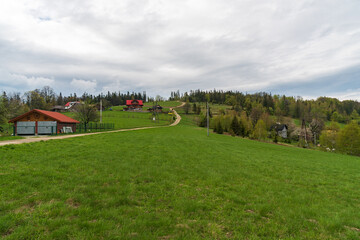 Fototapeta na wymiar Ceslar hill in Slezske Beskydy mountains on czech - polish borders with meadow, few houses and trees