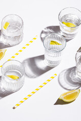 Mineral water with lemon on white background. Hard light