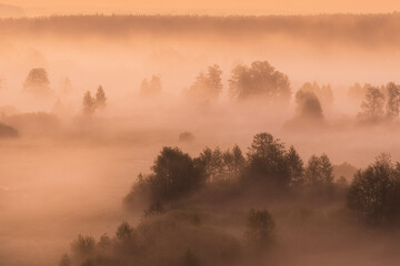 Naklejka premium Beautiful countryside sunrise landscape. Early morning fog rolling over scenic green landscape. Aerial view. HDR photography