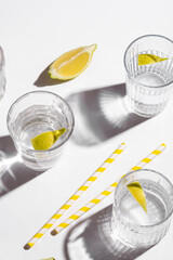 Mineral water with lemon on white background. Hard light
