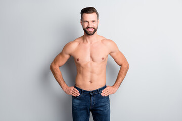 Fototapeta premium Portrait of attractive cheerful groomed content fit guy hands on hips protein power isolated over light grey color background