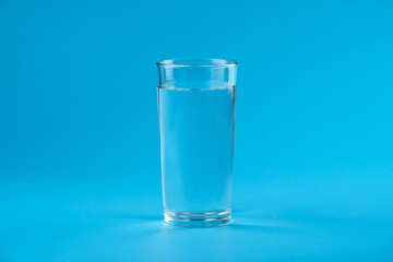 Clean water in a glass on a blue background