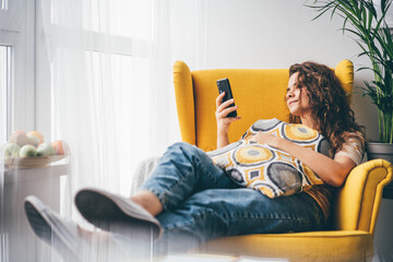 Young Woman at Home Using Smartphone with smile.