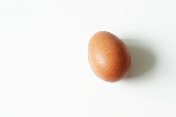 minimalism food photography, raw fresh brown egg on white background
