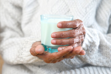 senior women hand holding a glass of milk 