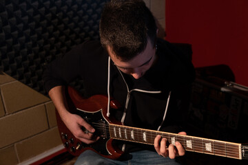 Man playing the guitar at the studio