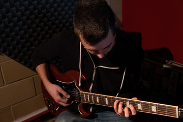Obraz premium Man playing the guitar at the studio