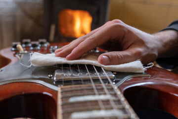 close up of a man cleaning guitar