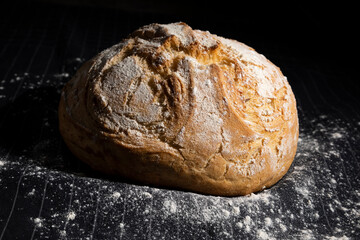 Traditional bread on a black cloth with flour.