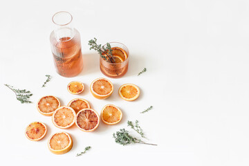 Fresh blood oranges pattern. Whole and cut fruits with thyme herb isolated on white table backgrounds. Lemonade drink, cocktail in glass caraffe. Food concept. Summer frame, web banner. Flat lay, top