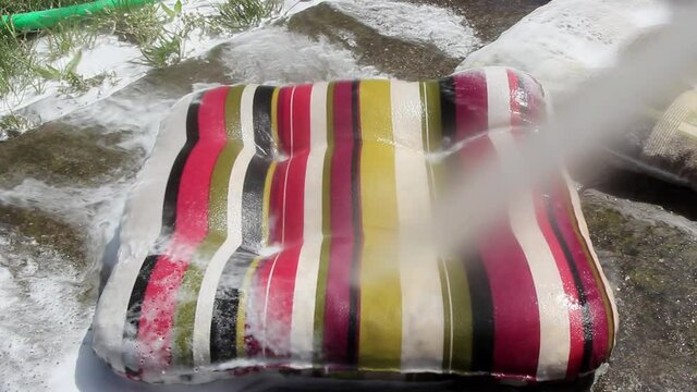 Cleaning the colorful colorful chair cushion with a high pressure water gun