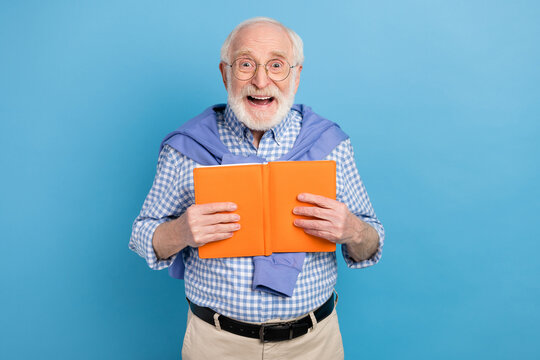 Photo of impressed old grey hairdo man hold book wear spectacles blue shirt isolated on pastel color background