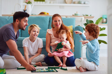 cheerful family having fun, spending time together by playing board games at home