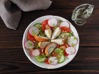 Slices of smoked egg, tomatoes, cucumber, radish with green onions and spices in a plate, olive oil on a dark wooden table, flat layout. Recipe for vitamin salad with chicken eggs