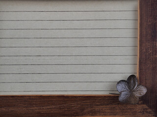 Wooden vintage photo frame with dried flowers. An empty brown frame with scuffs, old notepaper with...
