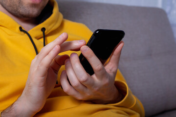 Man is searching in cell phone. Close-up.