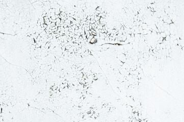 Vintage background close-up. Old faded white paint with cracks and peeling, rough textured surface.