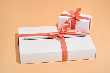Two gift box with red bows on orange background