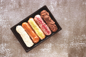 Box of eclairs on gray background.