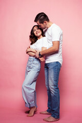 young cheerful caucasian couple together having fun on pink background, guy ang girl modern relationship, lifestyle people concept