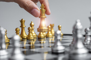 businessman hand moving gold Chess King figure and Checkmate opponent during chessboard competition. Strategy, Success, management, business planning, disruption and leadership concept