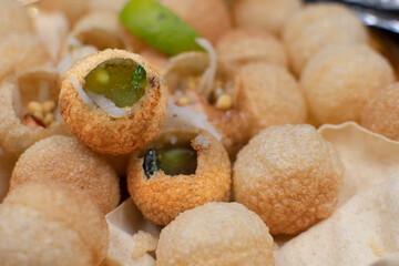 Indian pani puri served with potato, pickles and chutneys