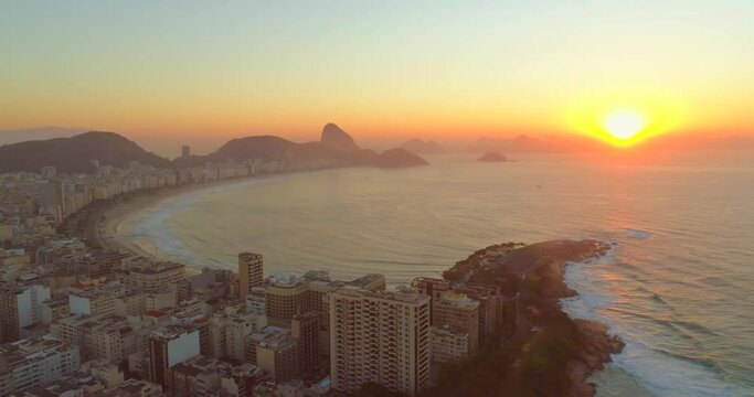 Aerial approaching Copacabana Beach, ocean and Sugarloaf mountain at sunrise in Rio de Janeiro Brazil