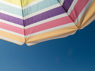 beach umbrella in the summer of spain with multi coloredin a blue sky

