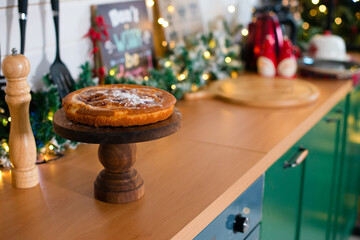 Homemade cake in the kitchen at new year decoration. New Year's kitchen in green colors.