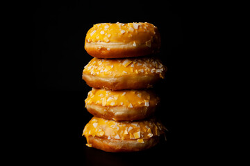 on the table are four mango doughnuts, stacked on top of each other