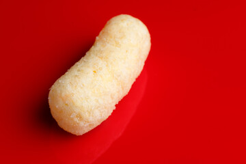 one sweet corn stick on glossy red background close up macro